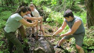 Crew muscles a large step stone into place on the Appalachian Trail near Moose Mountain