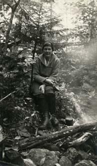 Miss ‘Pete’ Mayer sits near a campfire on a trail in the White Mountains, North Chatham, New Hampshire, September 16, 1919. Photograph by Ralph C. Larrabee.