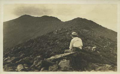 Woman sitting at summit. Museum of the White Mountains