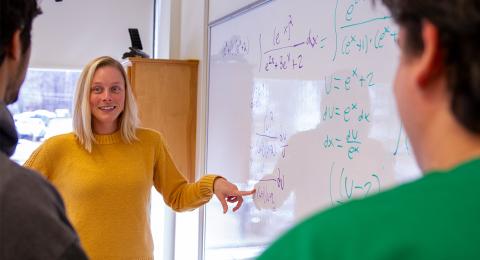 Math teacher teaching math on a whiteboard