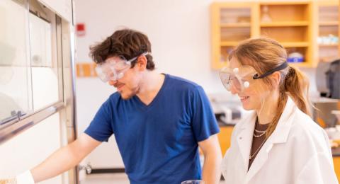 Students wearing protective goggles working in a lab.