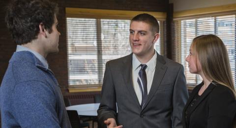 Student shaking hands at a business event.