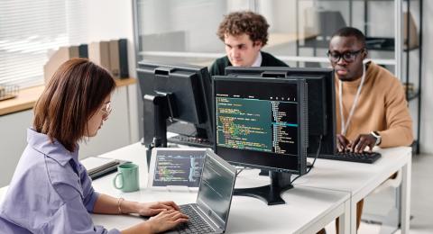Three persons at cybersecurity computers