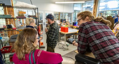A group of people having a discussion in an active robotics working space.