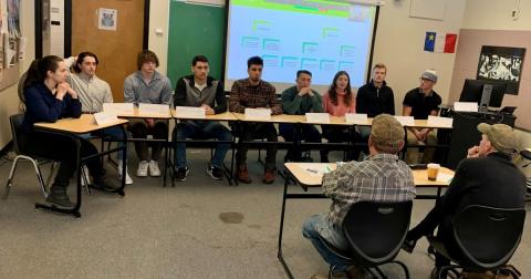A group of students giving recommendations to country store owners.