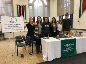 Student Support Foundation members stand behind their table with a poster about the organization to the right at the Student Activities Fair.