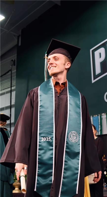 Student receives their degree and wears their graduation gown.
