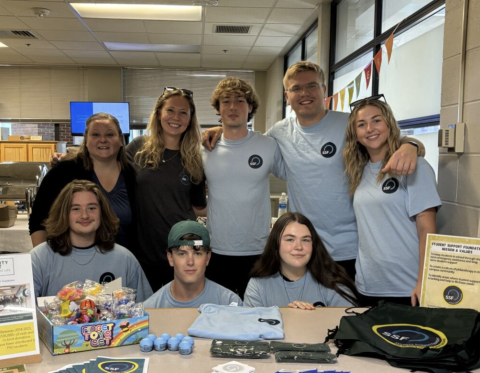 Group of individuals at a table, smiling for a photo.
