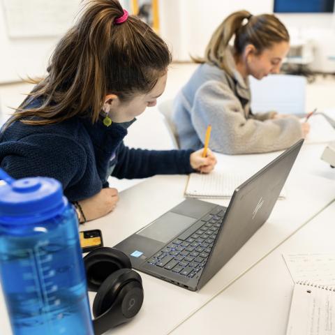 Students write onto a notebook