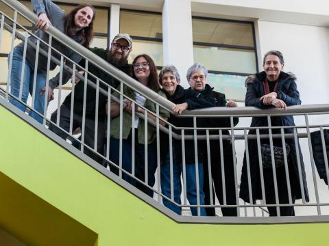 Students standing over a balcony, smiling at the camera