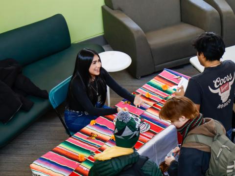 Students at a table speaking to one another